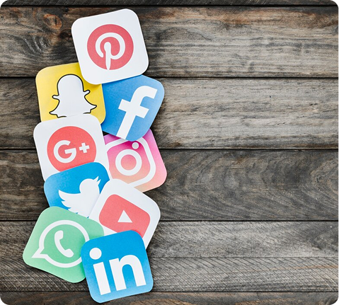 Social media app icons arranged on a wooden surface