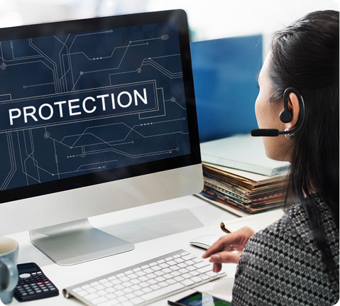Person at a desk reviewing a monitor displaying protection status